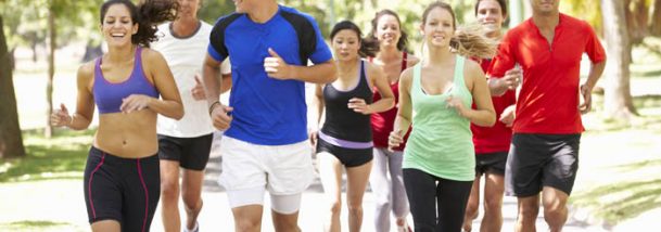 Group Of Runners Jogging Through Park